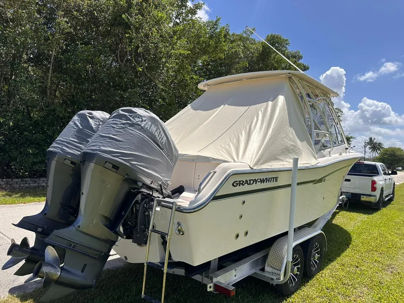 Slide: The Image of 2011 Grady-White Freedom 275 boat on trailer, twin engines, parked outdoors. - 35