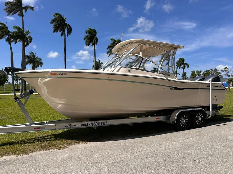 Slide: The Image of 2011 Grady-White Freedom 275 boat on trailer, parked under clear blue sky. - 7