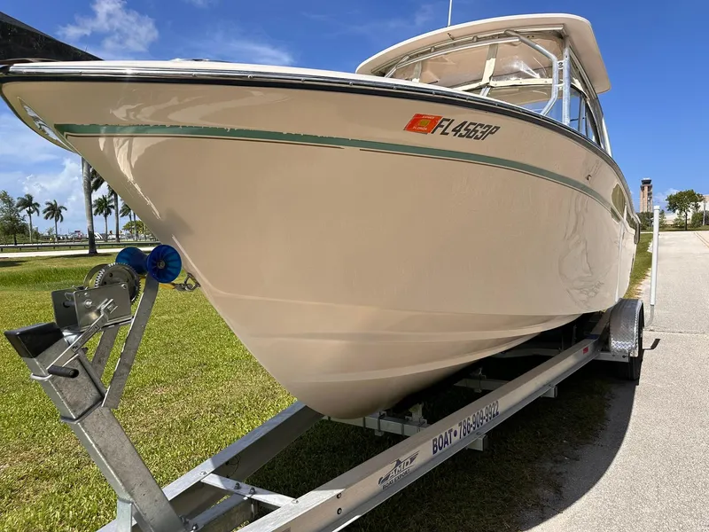 Slide: The Image of 2011 Grady-White Freedom 275 boat on trailer, parked outdoors under clear blue sky. - 8