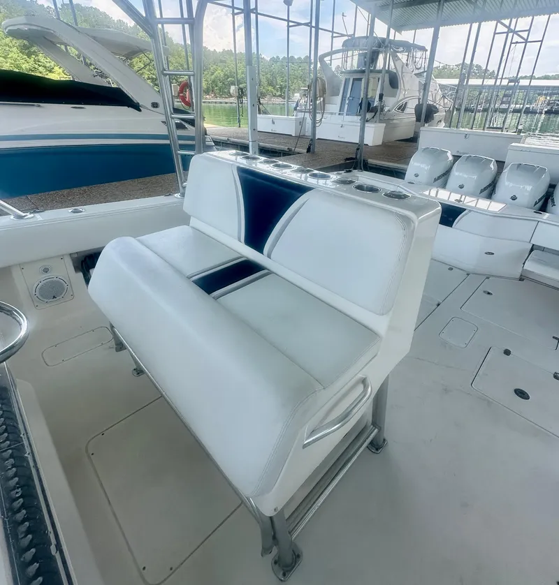 Slide: The Image of 2008 SeaVee 390B boat with white and blue seating, docked in a marina. - 22