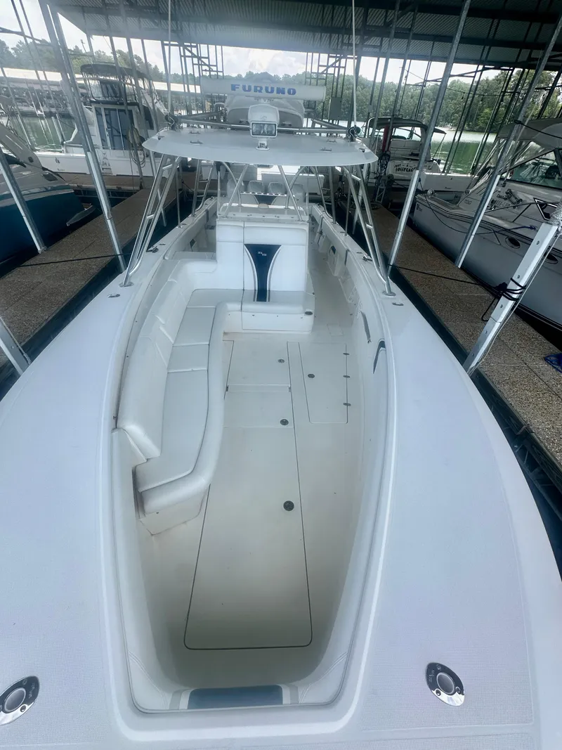 Slide: The Image of 2008 SeaVee 390B boat with spacious deck and seating, docked in a covered marina. - 26