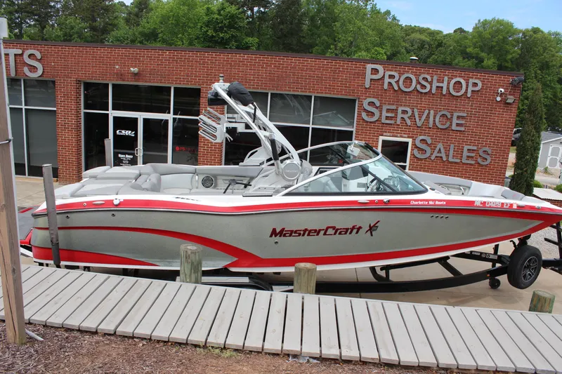 Slide: The Image of 2016 MasterCraft X26 boat displayed outside a pro shop, featuring sleek design and red accents. - 4