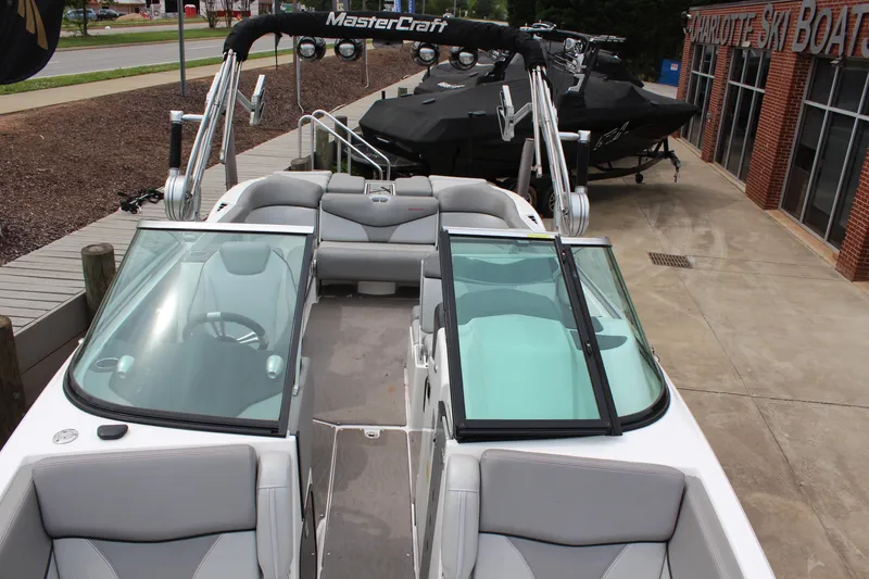 Slide: The Image of 2016 MasterCraft X26 boat with open seating and sleek design, displayed outdoors. - 8