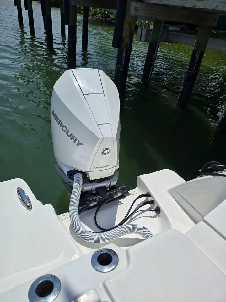 Slide: The Image of 2023 Caymas 30 CT boat with Mercury outboard motor, docked on calm water. - 10