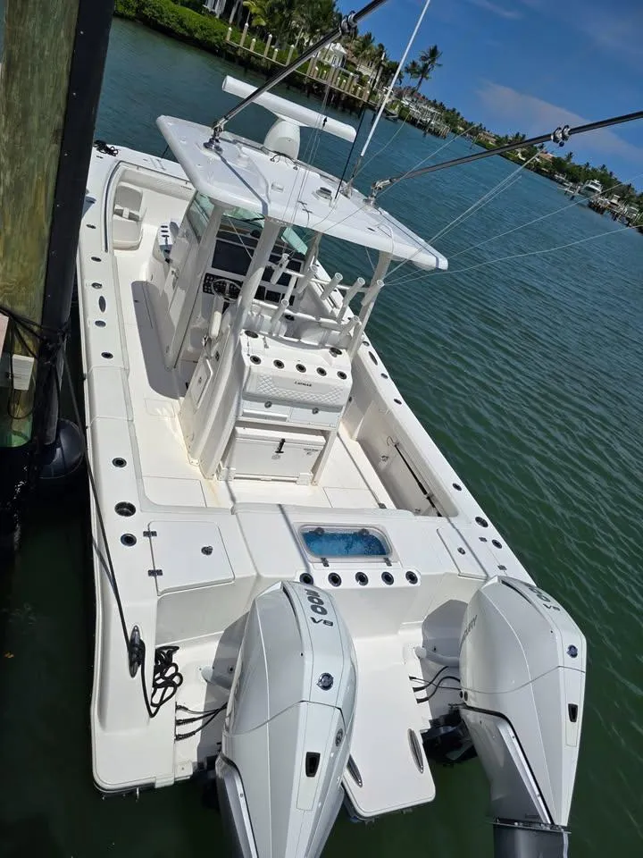 Slide: The Image of 2023 Caymas 30 CT boat docked on calm water, featuring dual engines and spacious deck. - 18