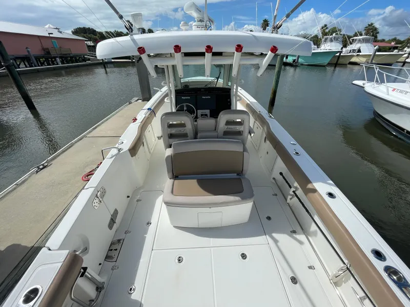 Slide: The Image of 2018 Boston Whaler 330 Outrage boat interior at marina, showcasing seating and helm. - 10