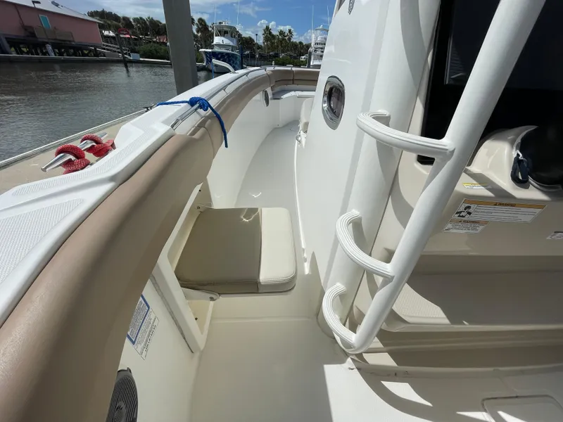 Slide: The Image of 2018 Boston Whaler 330 Outrage boat deck with seating and railing, docked by the water. - 15