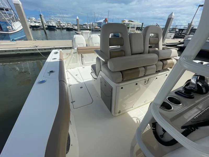 Slide: The Image of 2018 Boston Whaler 330 Outrage boat interior at marina, featuring seating and control panel. - 20