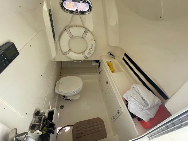 Slide: The Image of 2018 Boston Whaler 330 Outrage cabin with toilet, life preserver, and storage. - 21