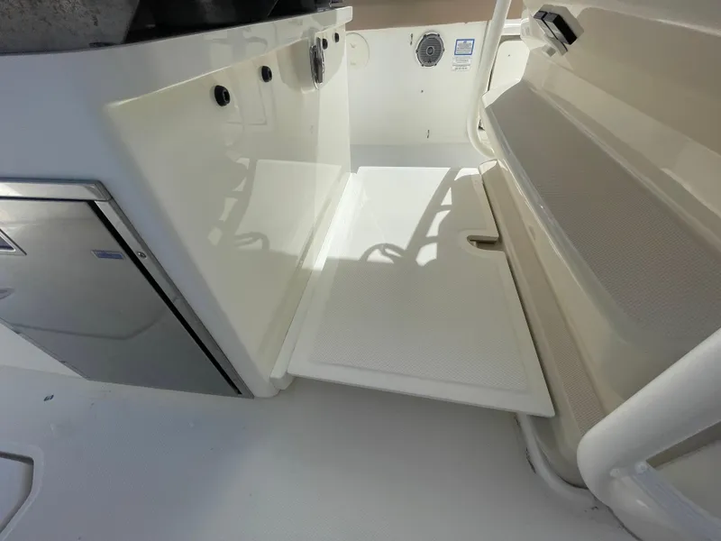 Slide: The Image of 2018 Boston Whaler 330 Outrage interior with fold-out step and storage compartment. - 22