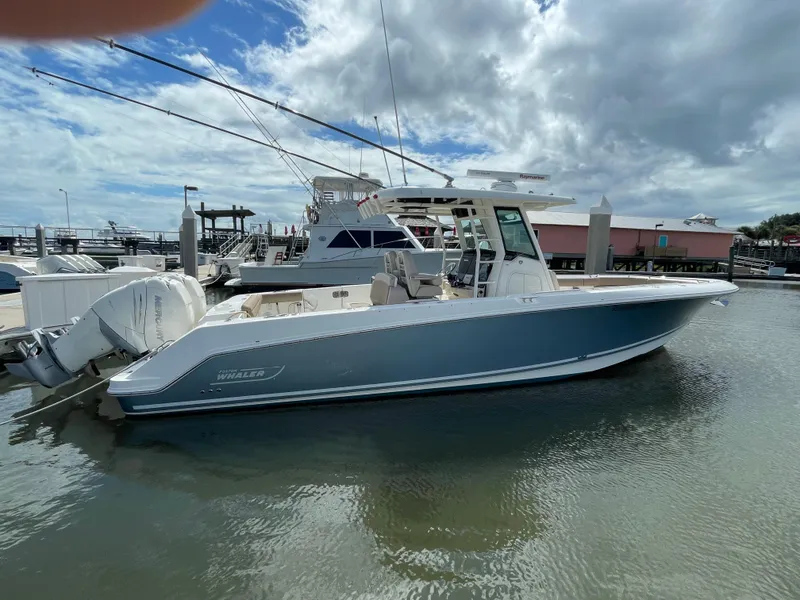 Slide: The Image of 2018 Boston Whaler 330 Outrage boat docked in marina under cloudy sky. - 3