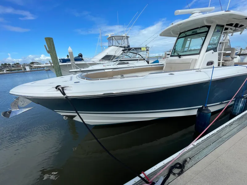 Slide: The Image of 2018 Boston Whaler 330 Outrage boat docked at marina under clear blue sky. - 5