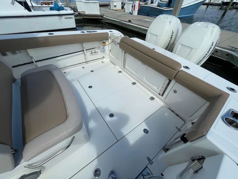 Slide: The Image of 2018 Boston Whaler 330 Outrage boat interior with seating and twin engines. - 6