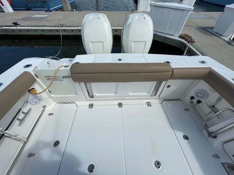 Slide: The Image of 2018 Boston Whaler 330 Outrage boat deck with twin engines at dock. - 7