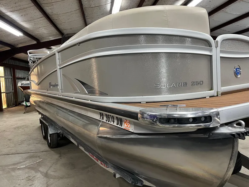 Slide: The Image of 2019 Premier 250 Solaris pontoon boat in a storage facility. - 2