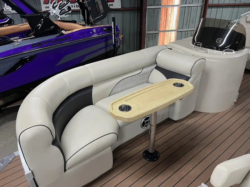 Slide: The Image of 2019 Premier 250 Solaris boat interior with beige seating and table, wooden deck flooring. - 7