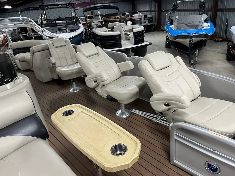 Slide: The Image of 2019 Premier 250 Solaris pontoon boat with luxurious seating and wooden deck in a showroom. - 8