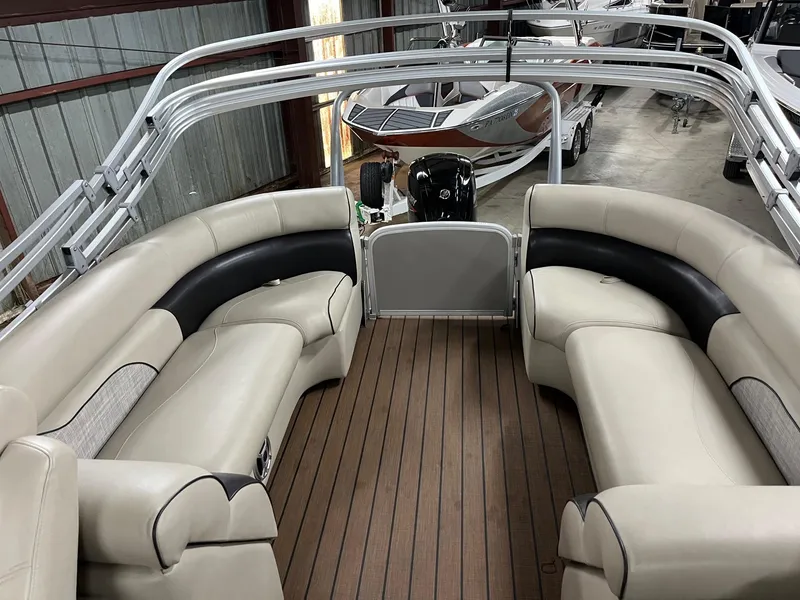 Slide: The Image of 2019 Premier 250 Solaris boat interior with beige seating and wood flooring in a showroom. - 9