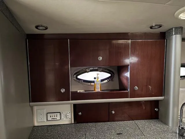 Slide: The Image of 2005 Formula 400 SS yacht interior with wooden cabinets and porthole window. - 16