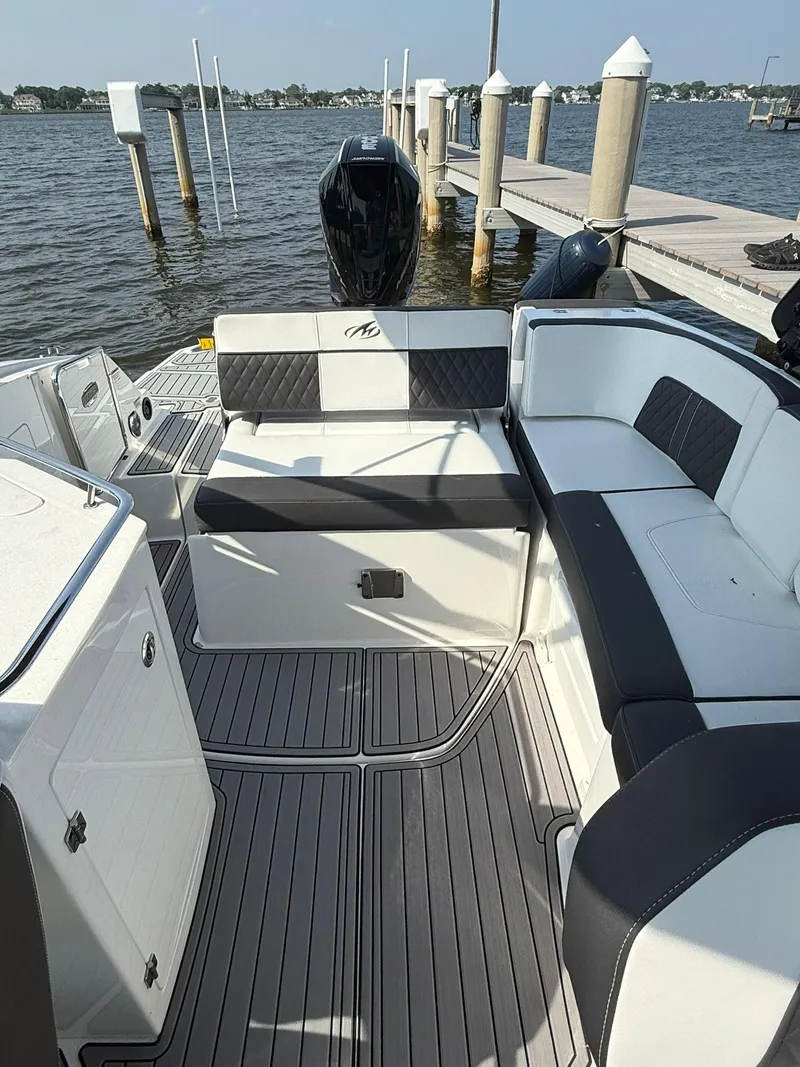 Slide: The Image of 2023 Monterey M65 boat interior with sleek seating and modern design at a dock. - 14