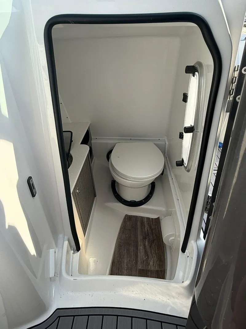 Slide: The Image of 2023 Monterey M65 boat interior bathroom with toilet and window. - 17