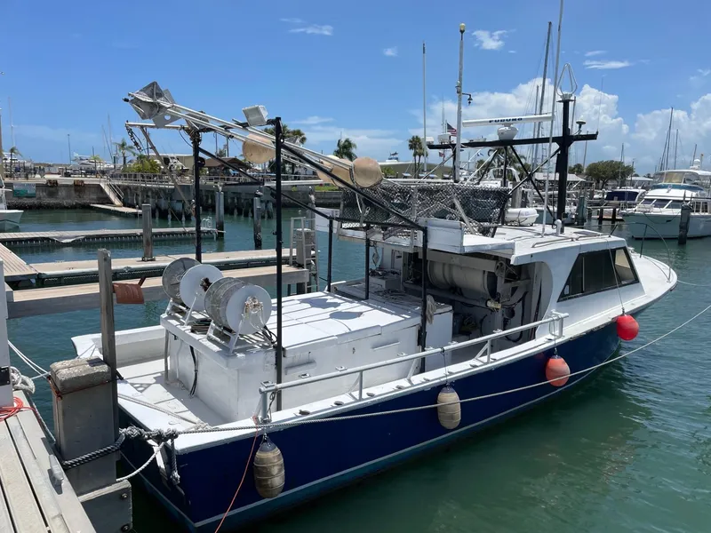 Slide: The Image of 1983 Commercial Hull #1 Key West boat docked in marina under clear sky. - 1