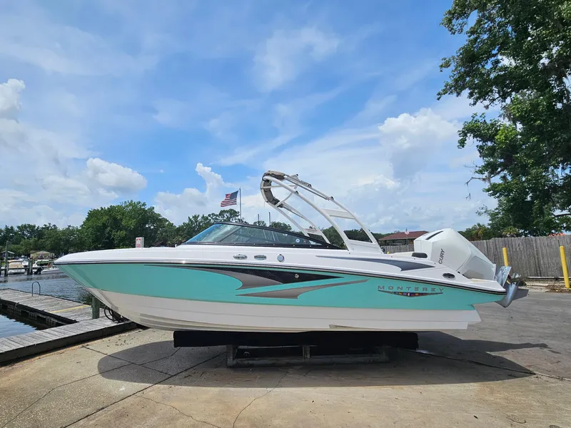 Slide: The Image of 2025 Monterey M-225 boat docked under a clear blue sky. - 1