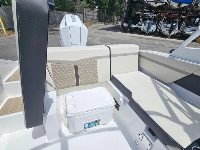 Slide: The Image of 2025 Monterey M-225 boat interior with cushioned seating and cooler storage. - 10