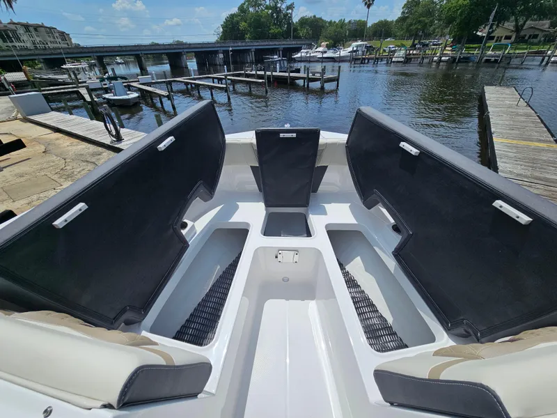 Slide: The Image of 2025 Monterey M-225 boat interior with open storage compartments, docked by a scenic waterfront. - 21