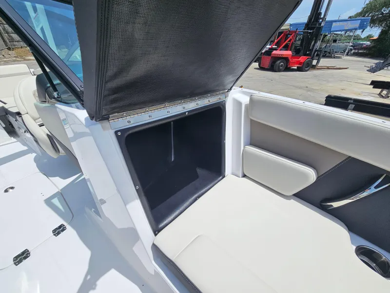 Slide: The Image of 2025 Monterey M-225 boat interior storage compartment with open hatch, showcasing seating and design. - 23