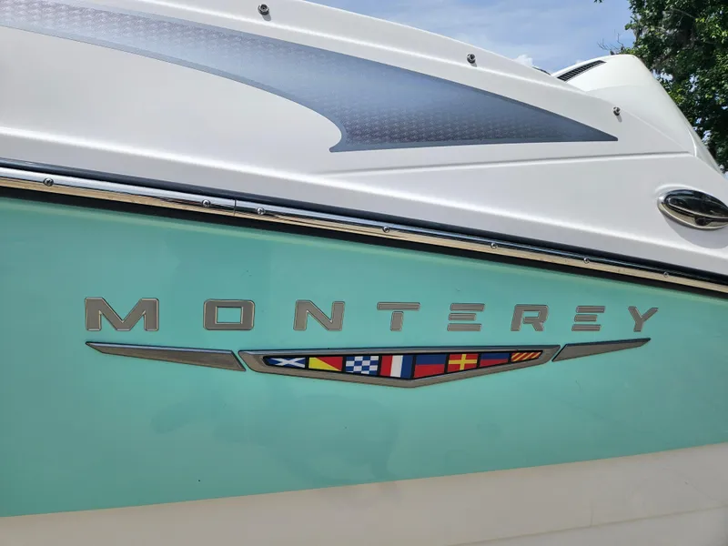 Slide: The Image of 2025 Monterey M-225 boat with nautical flags and sleek design. - 24