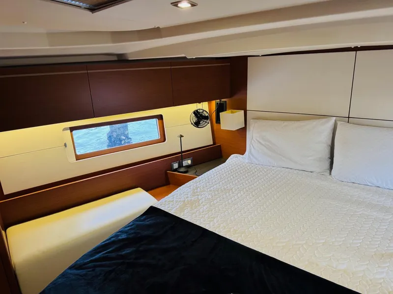 Slide: The Image of Luxurious cabin interior of 2020 Beneteau Oceanis 51.1 yacht with cozy bedding and window view. - 10