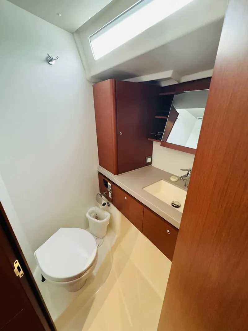 Slide: The Image of 2020 Beneteau Oceanis 51.1 yacht bathroom with modern fixtures and wooden cabinetry. - 13
