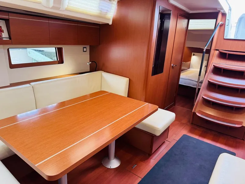 Slide: The Image of Luxurious interior of 2020 Beneteau Oceanis 51.1 yacht with wooden dining area and staircase. - 28