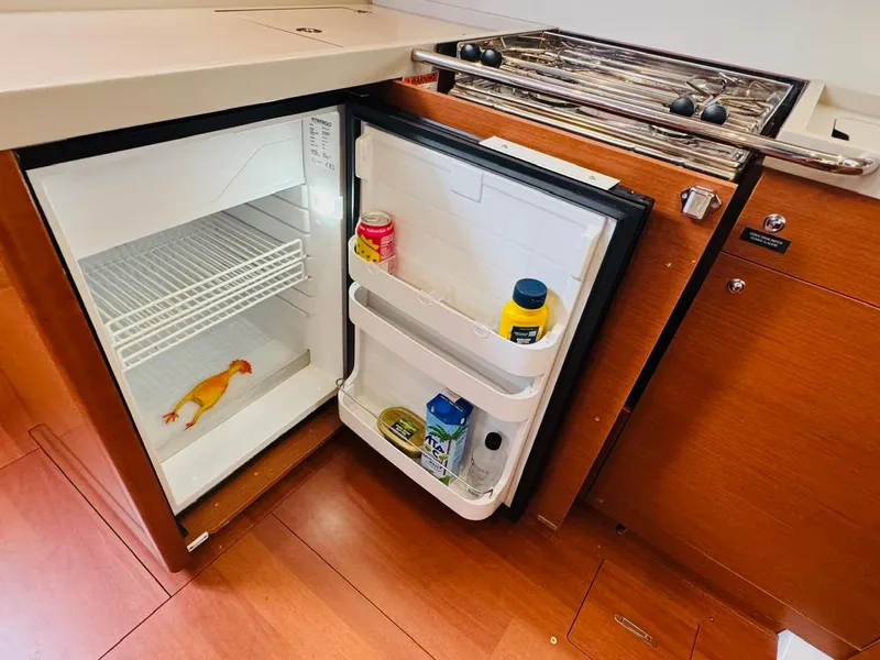 Slide: The Image of Open fridge in Beneteau Oceanis 51.1 yacht kitchen, containing condiments and a rubber chicken. - 36