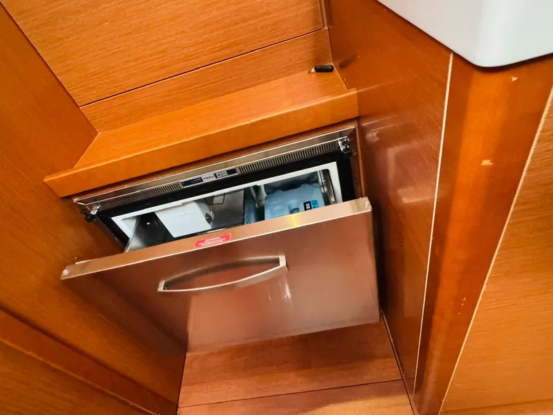 Slide: The Image of Built-in drawer refrigerator on 2020 Beneteau Oceanis 51.1 yacht, featuring sleek wood paneling. - 38