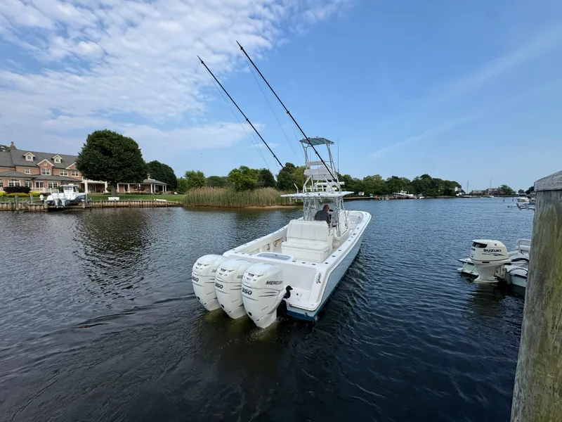 Slide: The Image of 2016 Invincible 39 Open Fisherman boat with triple outboard engines on a calm river. - 10