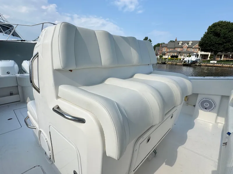 Slide: The Image of 2016 Invincible 39 Open Fisherman boat with white cushioned seating, dockside view. - 13
