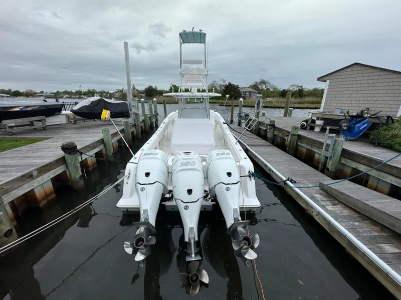 Slide: The Image of 2016 Invincible 39 Open Fisherman boat docked with triple outboard engines. - 19