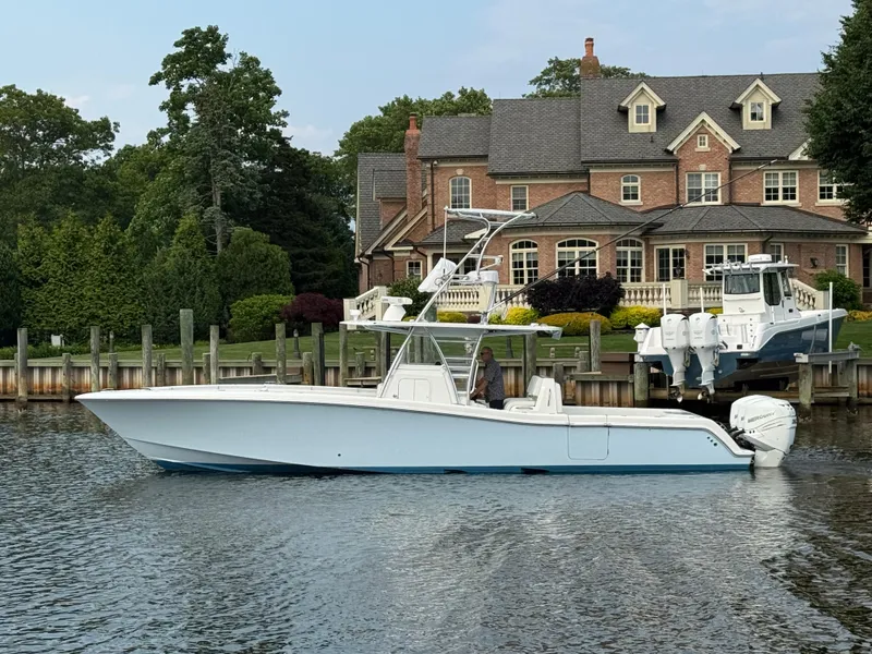 Slide: The Image of 2016 Invincible 39 Open Fisherman boat docked near a luxurious waterfront home. - 2