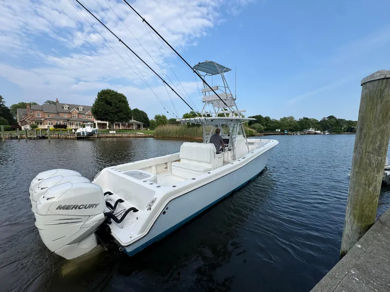 Slide: The Image of 2016 Invincible 39 Open Fisherman boat with twin Mercury engines docked on a calm river. - 8