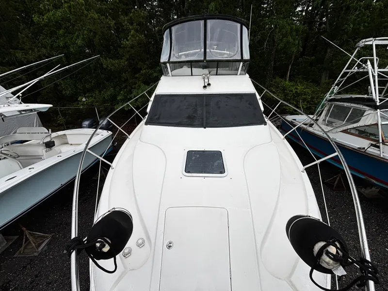 Slide: The Image of 2002 Silverton 330 Sport Bridge boat, docked with surrounding vessels, viewed from the bow. - 10