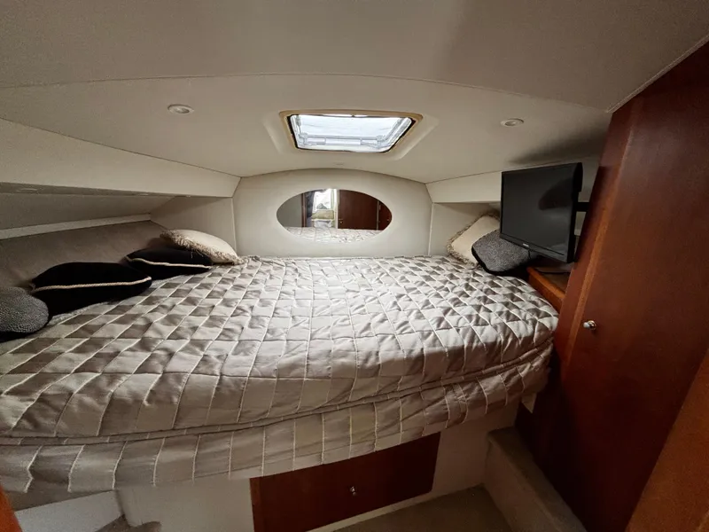 Slide: The Image of 2002 Silverton 330 Sport Bridge cabin with bed, skylight, and TV. - 11