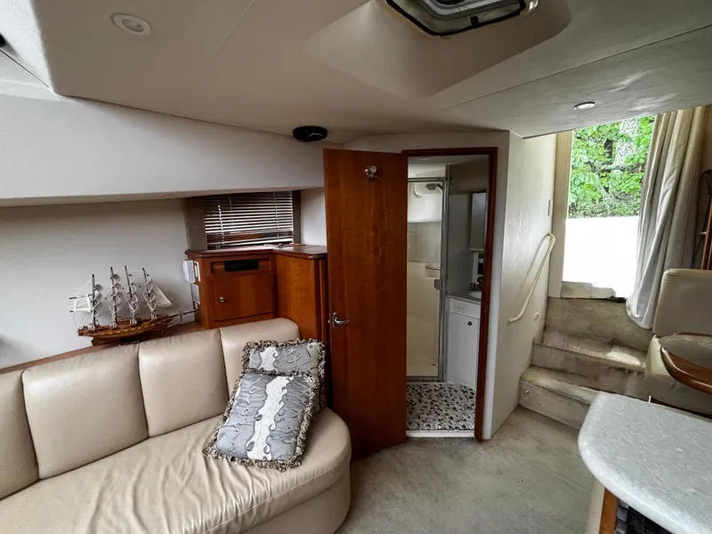 Slide: The Image of Interior of 2002 Silverton 330 Sport Bridge yacht with beige seating and wooden accents. - 15
