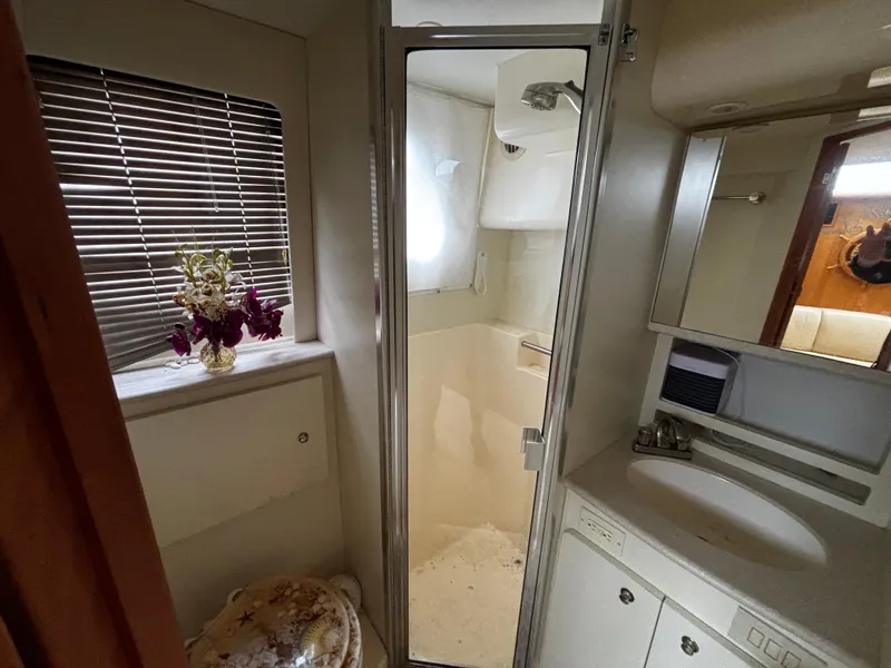 Slide: The Image of 2002 Silverton 330 Sport Bridge bathroom with shower, sink, and decorative flowers. - 7