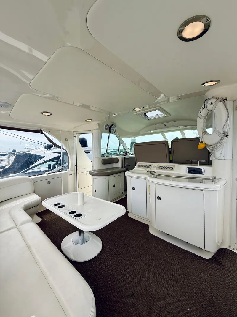 Slide: The Image of Interior of 2003 Sea Ray 480 Motor Yacht with white seating and modern amenities. - 15