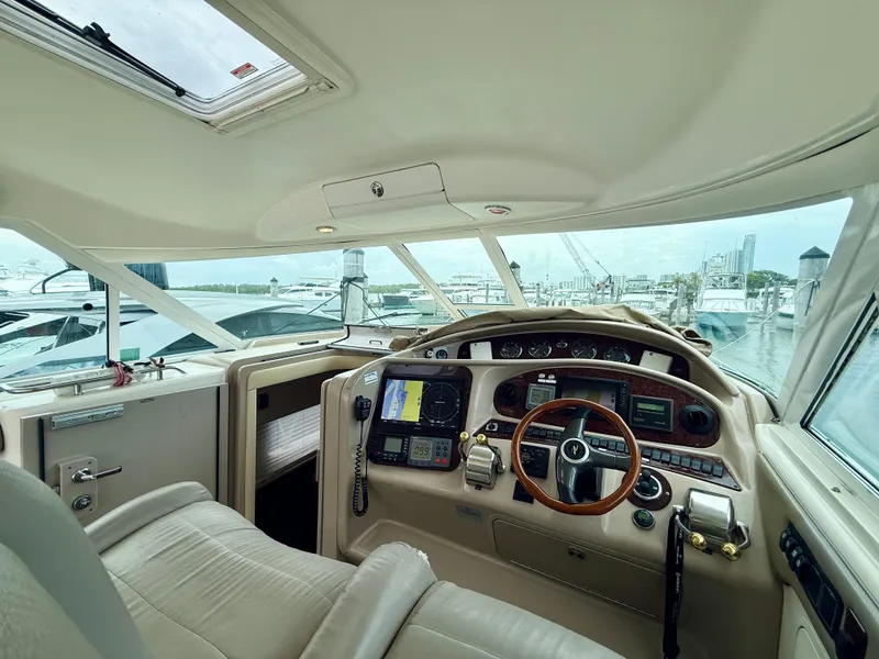 Slide: The Image of 2003 Sea Ray 480 Motor Yacht helm with navigation equipment and marina view. - 23