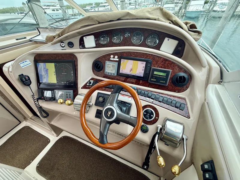 Slide: The Image of 2003 Sea Ray 480 Motor Yacht helm with navigation instruments and wooden steering wheel. - 26