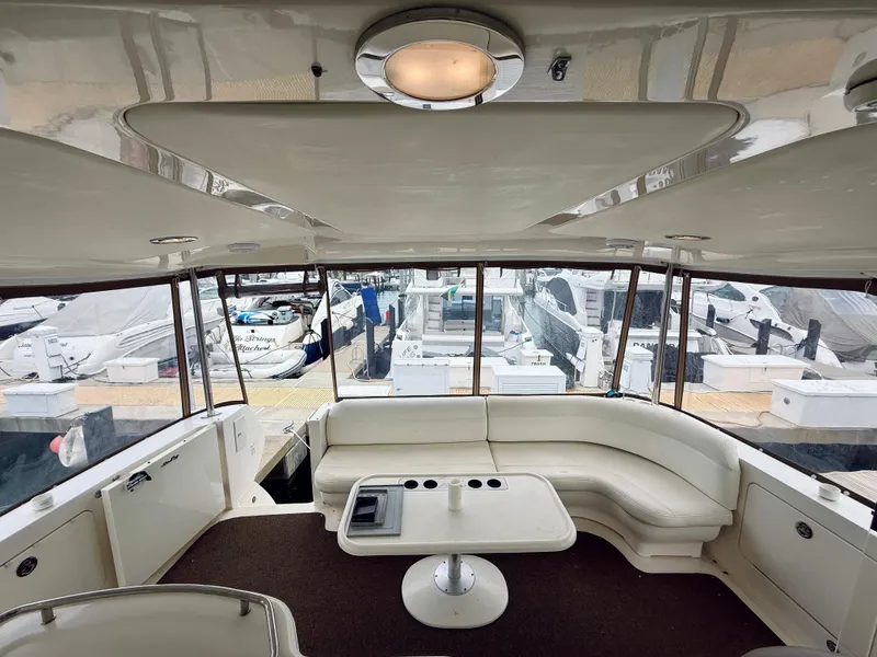 Slide: The Image of 2003 Sea Ray 480 Motor Yacht interior with white seating and marina view. - 30