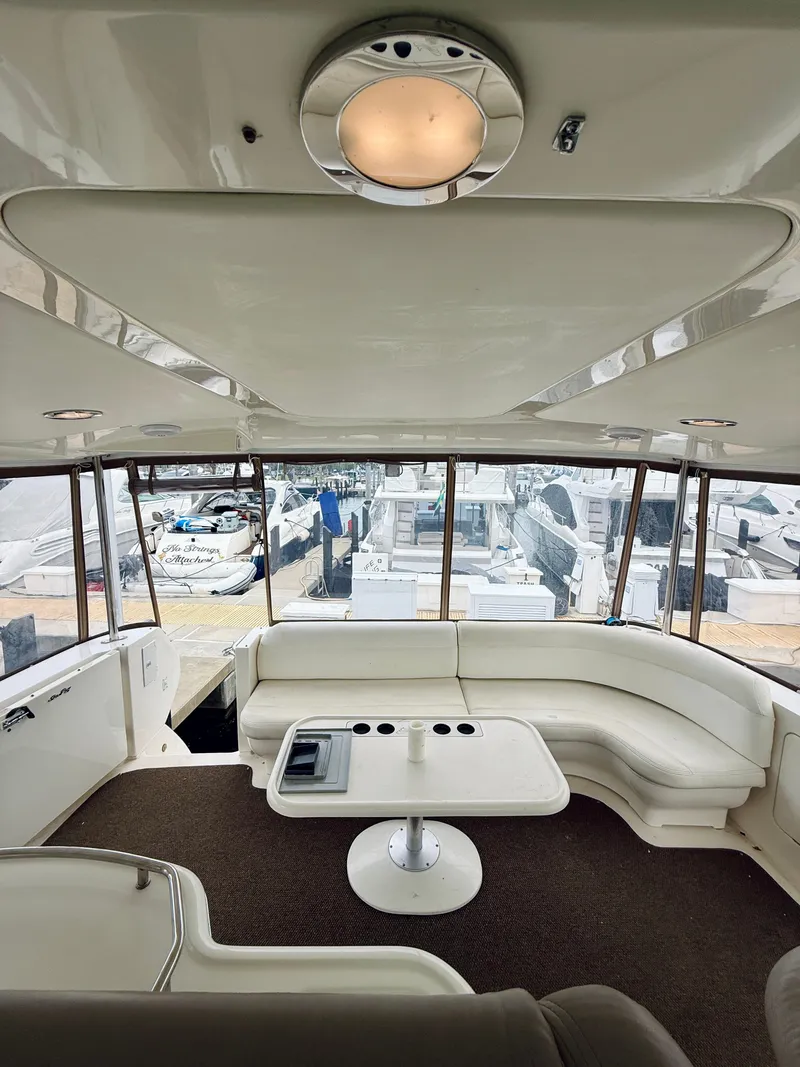 Slide: The Image of Interior of 2003 Sea Ray 480 Motor Yacht with white seating and table. - 31